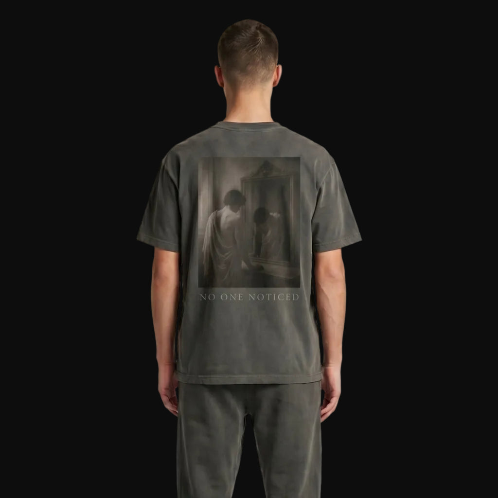 Person wearing a dark gray t-shirt and pants on a plain background