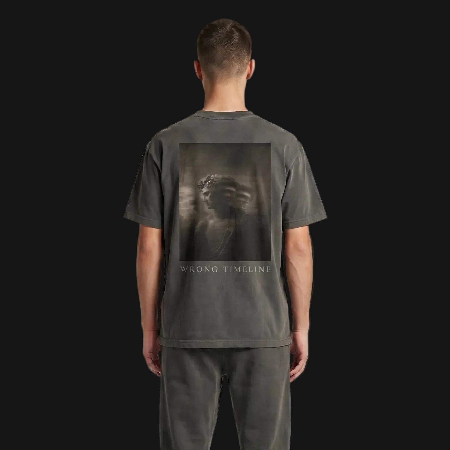 Person wearing a dark gray t-shirt and pants with a lion graphic on the back, standing against a plain background.